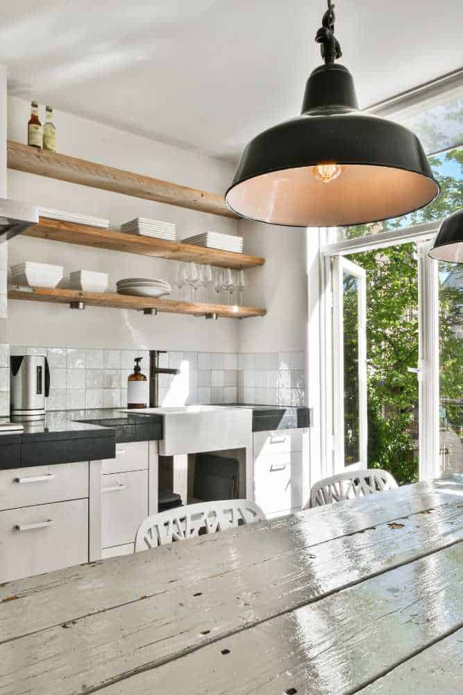 Modern kitchen featuring a warm wood table and bright white cabinets, designed by Nativi Construction in Ventura County.